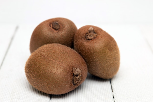 Kiwis sabrosos aislados en un fondo de madera blanco.