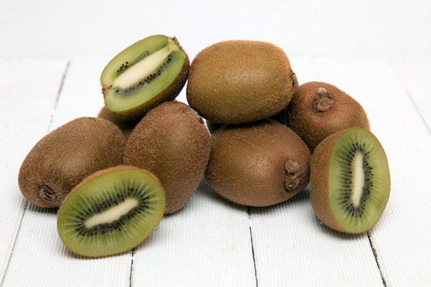 Kiwis sabrosos aislados en un fondo de madera blanco.