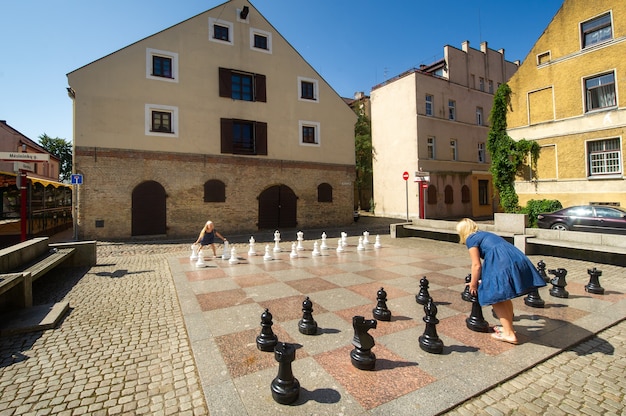 Klaipeda, Litauen Junge fröhliche Frau spielt zusammen mit einem kleinen Mädchen in großen Schach