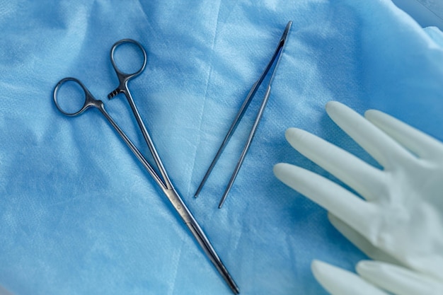 Klammern und Pinzetten für chirurgische Instrumente auf blauem Hintergrund im Operationssaal