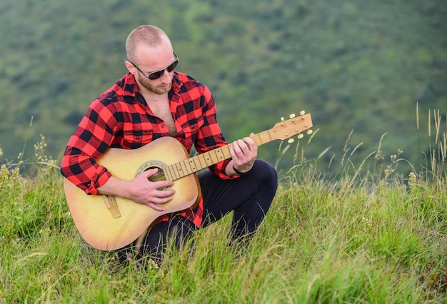 Klang der Freiheit Musiker Wanderer finden Inspiration in den Bergen Im Einklang mit der Natur Bleib ruhig und spiele Gitarre Mann mit Gitarre auf dem Gipfel Akustische Musik Musik für die Seele Musik machen