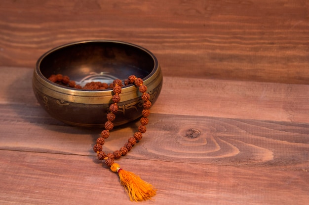 Klangschale und Rudraksha auf Holz