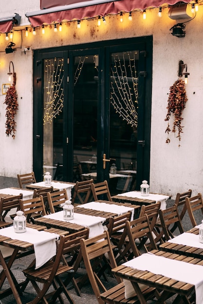 Klappstühle und Tische aus Holz in der Nähe der Tür eines Straßencafés