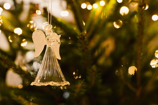 Foto klares glas-engel-ornament auf einem üppig grünen weihnachtsbaumzweig