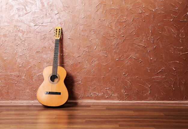 Klassische Akustikgitarre auf braunem Wandhintergrund