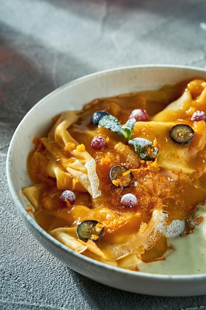 Klassische Crêpe-Suzette mit Orangenmarmelade-Eis und Beeren in einem Teller Ein köstliches Dessert