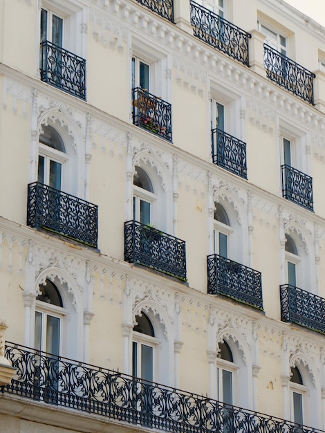 Klassische Fassade mit eleganten Balkonen und Fenstern, verziert mit Stuckbögen Madrid Spanien