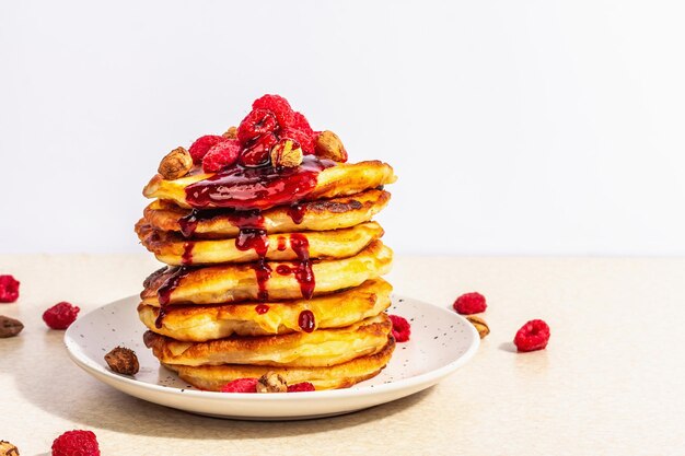 Klassische hausgemachte amerikanische Pfannkuchen mit gefrorenen Himbeeren Haselnuss und Minze Gesundes Frühstück