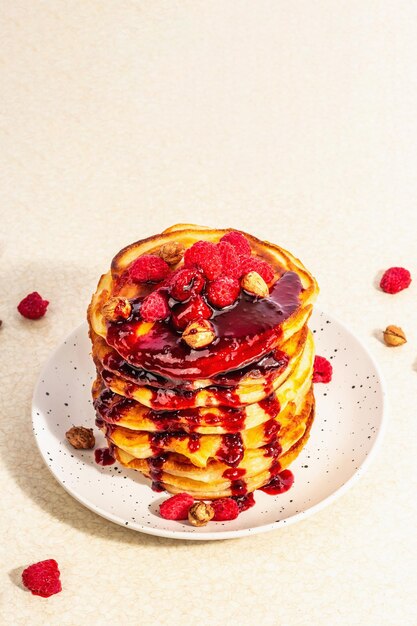 Klassische hausgemachte amerikanische Pfannkuchen mit gefrorenen Himbeeren Haselnuss und Minze Gesundes Frühstück