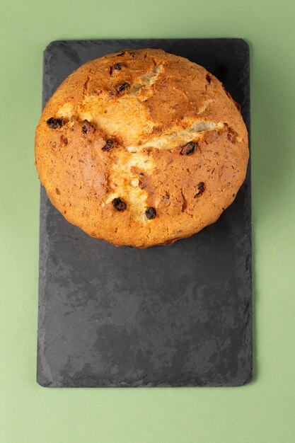 Klassische Hüttenkäsetorte mit Rosinen Auf einem Cupcake auf einem schwarzen Schneidebrett