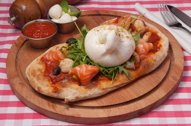 Klassische italienische Pizza mit Buratta-Käse und Lachs