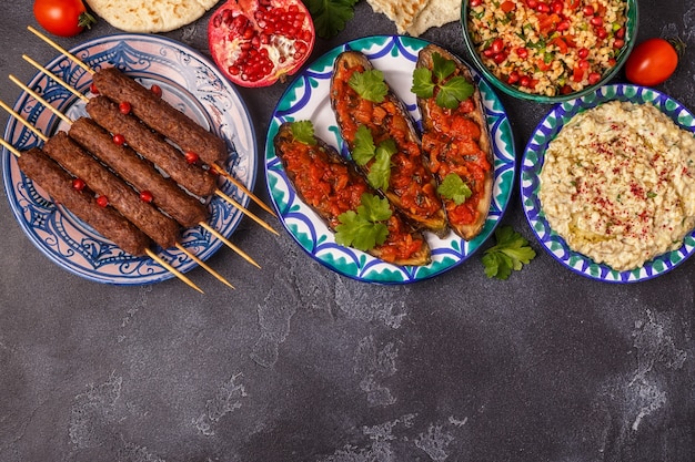 Klassische Kebabs, Tabouleh-Salat, Baba Ganush und gebackene Auberginen mit Sauce