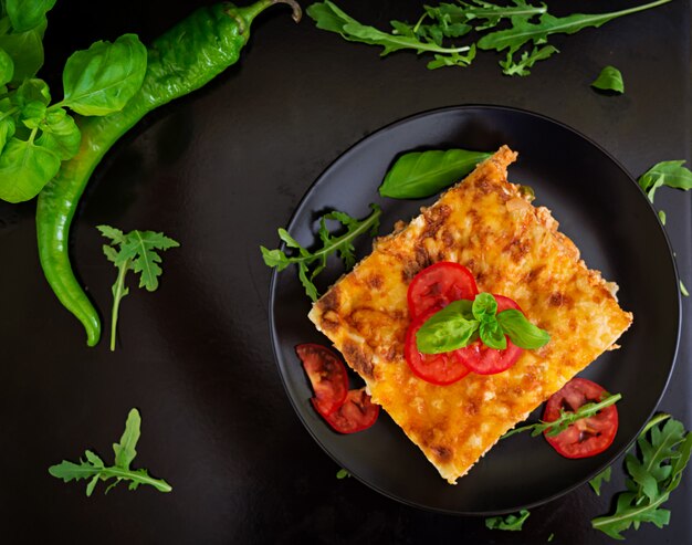 Klassische Lasagne mit Soße von Bolognese auf dunkler Oberfläche