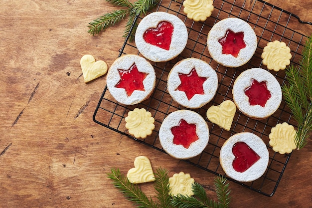 Klassische linzer weihnachtsplätzchen mit himbeer- oder erdbeermarmelade auf holztisch