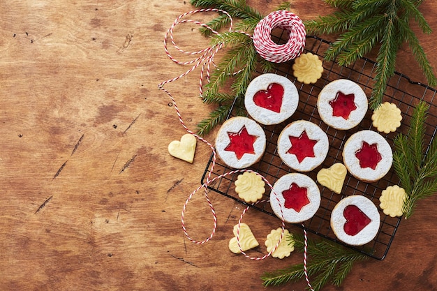 Klassische linzer weihnachtsplätzchen mit himbeer- oder erdbeermarmelade auf holztisch