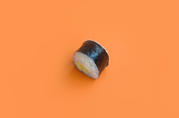 Klassische schwarze Sushi-Rolle auf leuchtend orangefarbenem Hintergrund