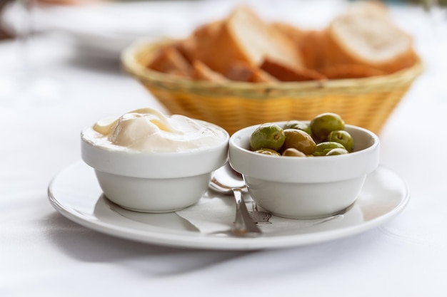 Klassische spanische Vorspeise Alioli hausgemachte Knoblauchmayonnaise mit grünen Oliven und hausgemachtem Brot