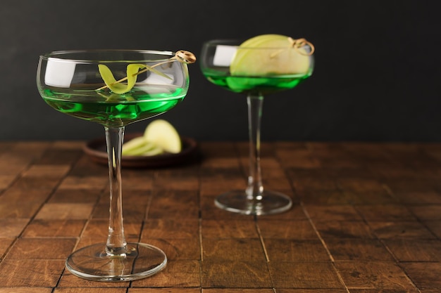 Klassischer Apple Martini Appletini kalter Sommercocktail auf schwarzem Hintergrund Platz für Text kopieren