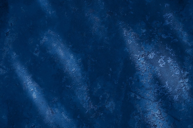 Klassischer blauer Texturhintergrund. Dunkle Wand in der Sonne