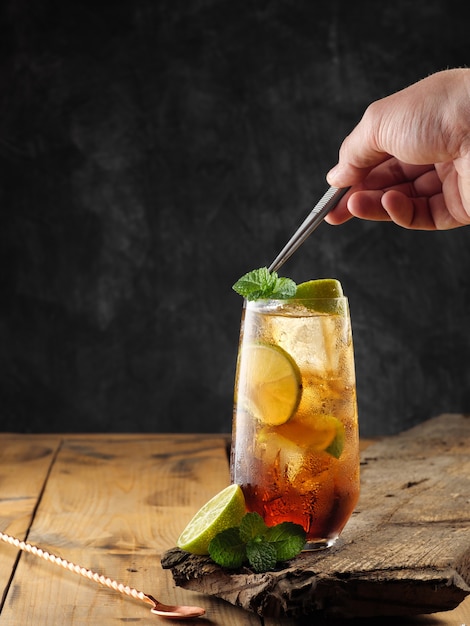 Klassischer Cocktail Cuba Libre auf einem Holztisch, Kopienraum.