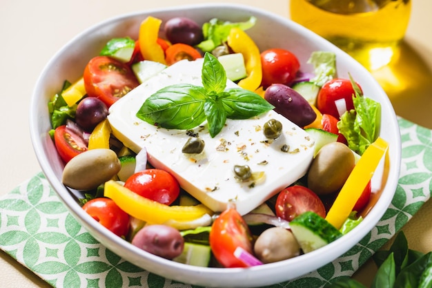 Klassischer griechischer Salat aus frischen Gurken, Tomaten, Paprika, Salat, roten Zwiebeln, Feta-Käse und Oliven mit Olivenöl