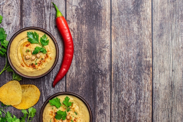 Klassischer Hummus in Schalen auf Holztisch. Draufsicht.