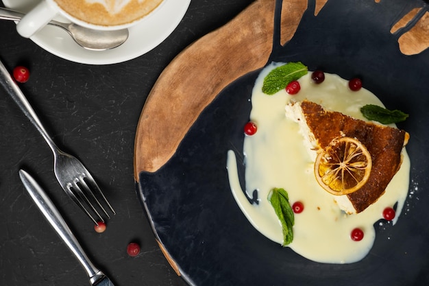 Foto klassischer käsekuchen auf schwarzem hintergrund dessert auf schwarzem hintergrund in einem schwarzen teller