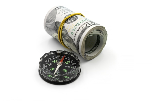 Klassischer Navigationskompass und Geldbündel Dollarrolle isoliert auf weißem Hintergrund