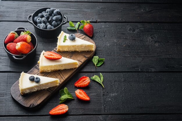 Klassischer New Yorker Käsekuchen, in Scheiben geschnitten, auf schwarzem Holztisch mit Kopierraum