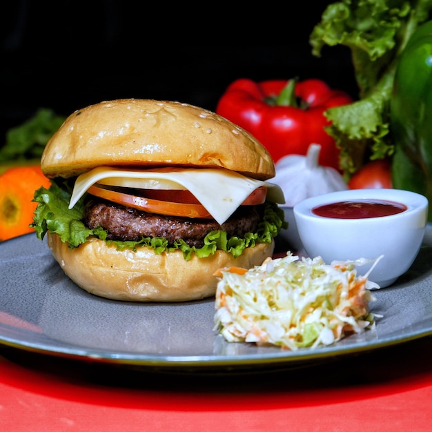 Klassischer Rindfleisch-Burger mit Sauce und Salat, serviert in Gericht-Seitenansicht von Fastfood