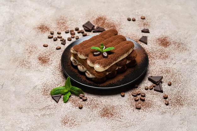 Klassisches Tiramisu-Dessert auf Keramikplatte auf Beton