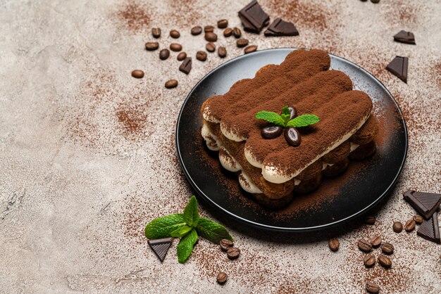 Klassisches Tiramisu-Dessert auf Keramikplatte auf Beton