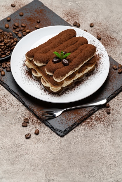 Klassisches Tiramisu-Dessert auf Keramikplatte auf Beton