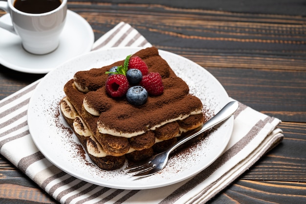 Klassisches Tiramisu-Dessert mit Himbeeren, Blaubeeren und einer Tasse Espresso