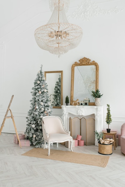 Klassisches Weihnachtsinterieur mit geschmücktem Weihnachtsbaum Kamin mit Sesselspiegel an der Wand