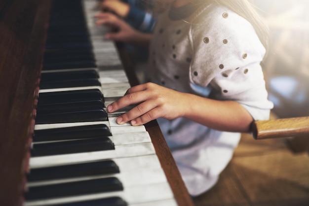 Klaviere öffnen die Schlüssel zu kindlichen Talenten Schnappschuss eines kleinen Mädchens, das Klavier spielt