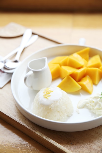 Klebreis mit Mango auf Holzhintergrund