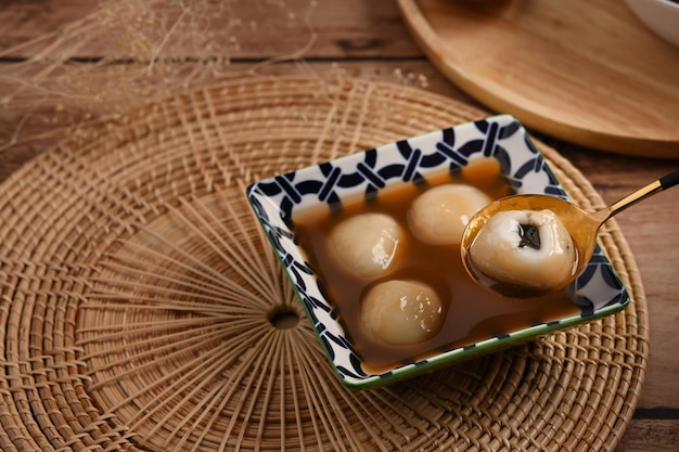 Klebreisbällchen mit gemahlenem schwarzem Sesam in süßer Ingwersuppe.