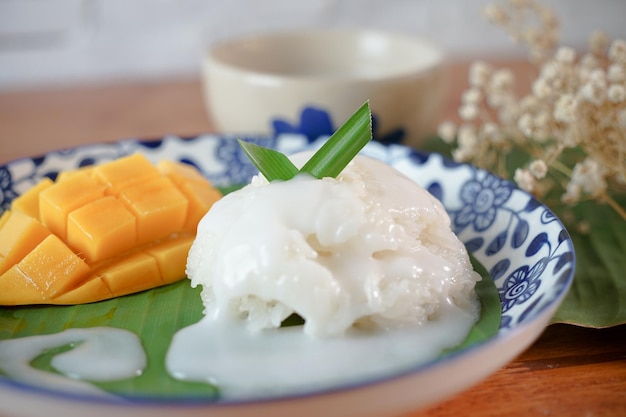 Klebriger Reis mit reifer Mango in Kokosmilch Authentische thailändische Desserts auf einem Holztisch