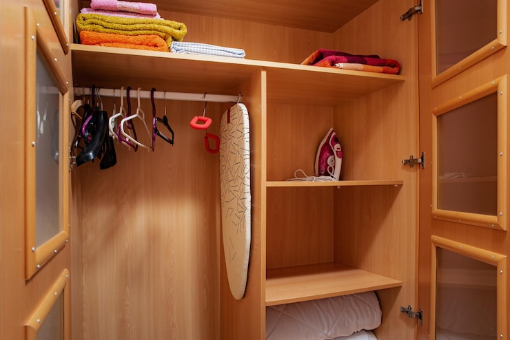 Foto kleiderbügel handtücher bügeleisen in einem offenen holzschrank