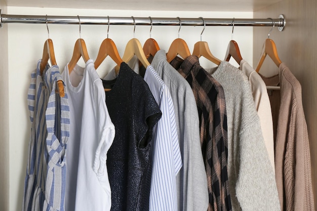Kleiderbügel mit verschiedenen Kleidungsstücken im Kleiderschrank