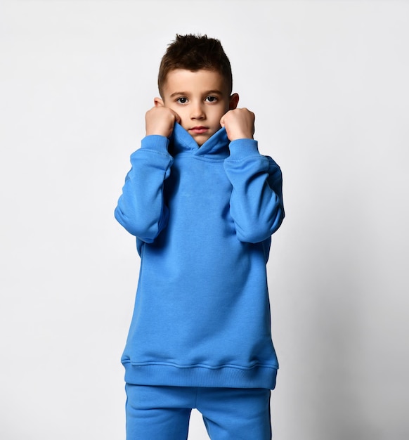 Kleidung für Schulkinder Studioporträt eines kleinen Jungen in einem trendigen blauen Sportanzug auf weißem Hintergrund Cooler Schuljunge in bequemer Kindersportbekleidung Banner