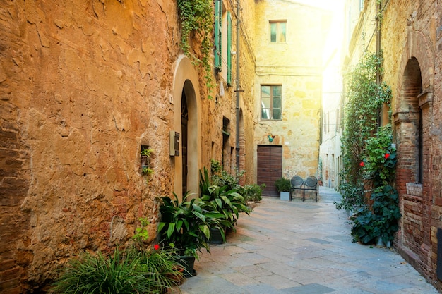 Kleine alte mediterrane Stadt schöne toskanische Straße in Pienza mit Sonnenschein und Blumen Italien