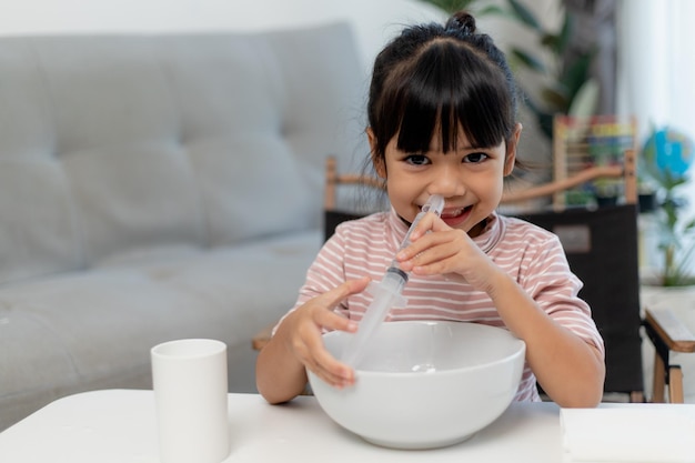 Kleine asiatische Mädchen salzige Nasenspülnase zu Hause