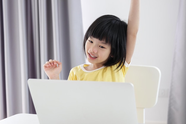 Kleine asiatische studentin lernt online mit laptop-computer zu hause
