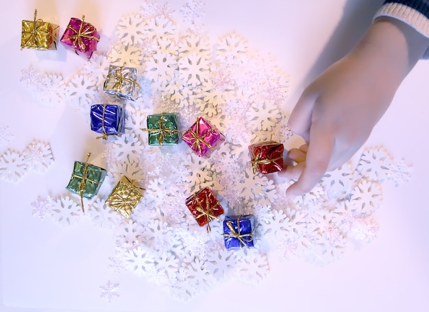 Kleine bunte Geschenkboxen in Kinderhänden. Weihnachts- und Silvesterdekorationsprozess.