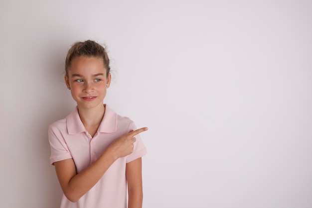 Kleine emotionale Teenager-Mädchen in rosa Polo-Shirts 11 12 Jahre alt auf einem isolierten weißen Hintergrund Children39s Studioportrait Platzieren Sie Text, um Platz für die Inschrift Werbung children39s Waren zu kopieren