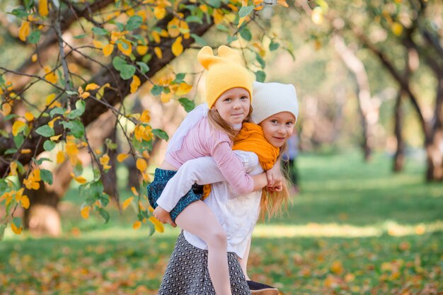 Kleine entzückende Mädchen am warmen Tag im Herbst parken draußen