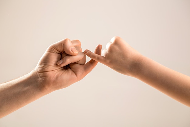 Kleine Finger der beiden Hände halten zusammen Zeigen Freundschaft und Vergebung