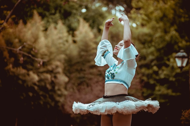 kleine Frau tanzt Ballett mit ihrem Kleid in der Natur